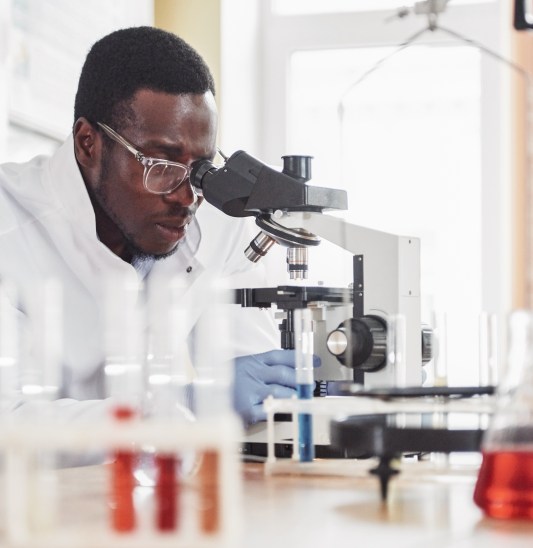 Scientists working with microscope in lab