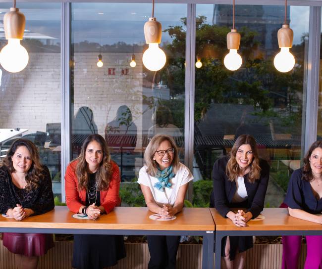Funcionárias mulheres da MSD sorrindo para a câmera