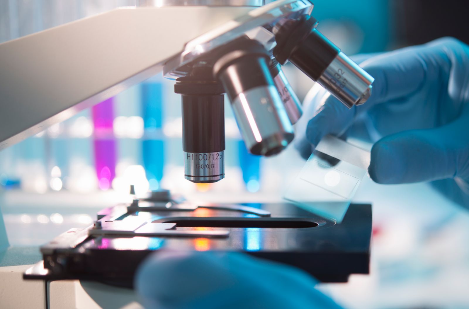 A scientist placing a slide under a microscope